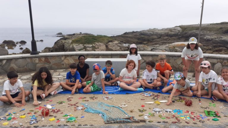 Nenos e nenas da Ocioteca de Verán en Burela crean mosaicos con pedras e cunchas na praia do Ril